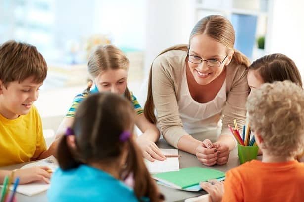 Teacher talking to her students in the classroom.