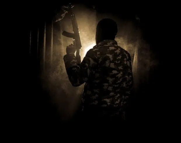 Silhouette of a man with assault gun
