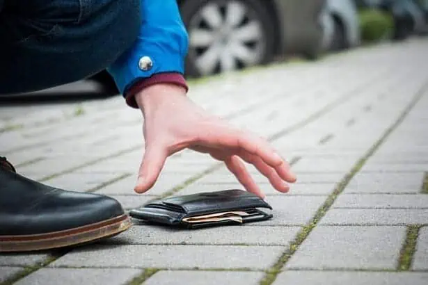 A man picking up a wallet full of money