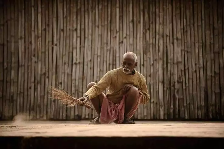 Top 15 Strange Superstition in India 4 An old man sweeping the floor during evening
