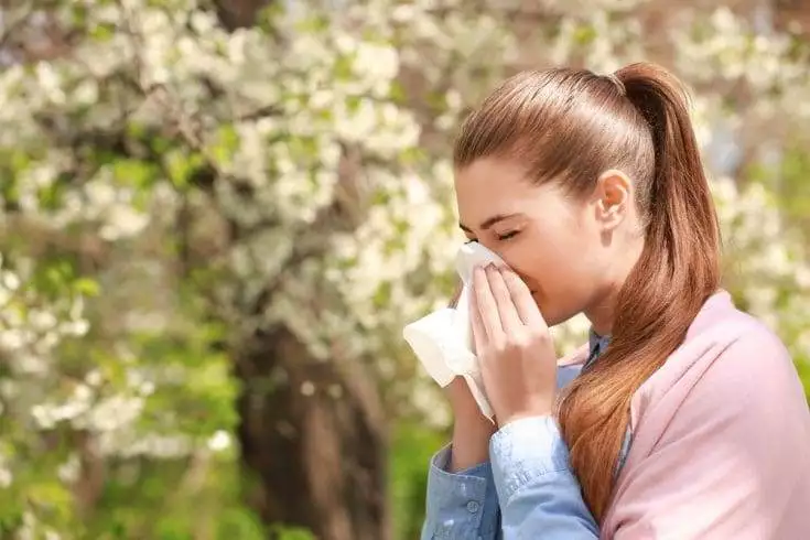 Top 15 Strange Superstition in India 9 Young girl sneezing into tissue paper at a park