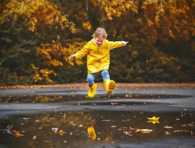 High on Rain. A happy child playing in the puddle of rainwater