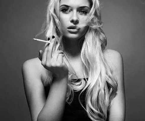 A black and white portrait of a woman smoking