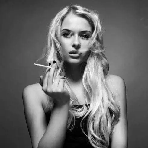 A black and white portrait of a woman smoking