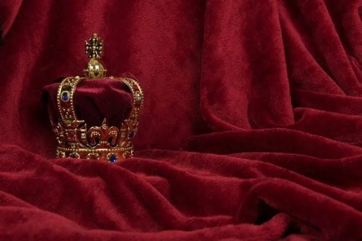 A golden crown placed on a red velvet