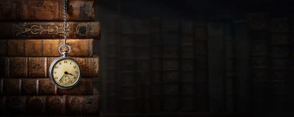 Vintage clock hanging from a pile of books