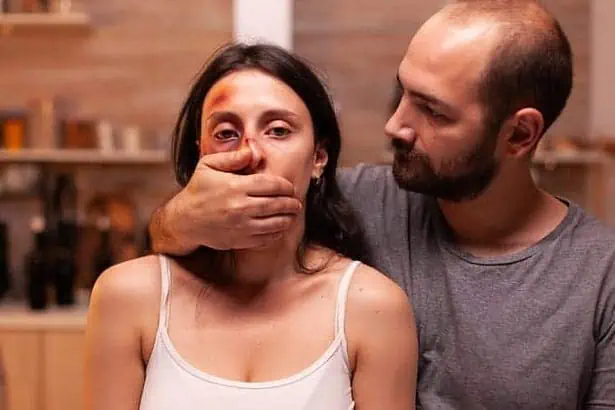 abusive marriage. An aggressive husband with his hand on his wife's mouth