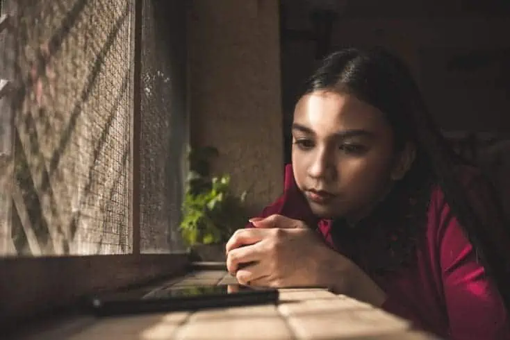 A young girl waiting anxiously for a text or phone call. Heartbroken