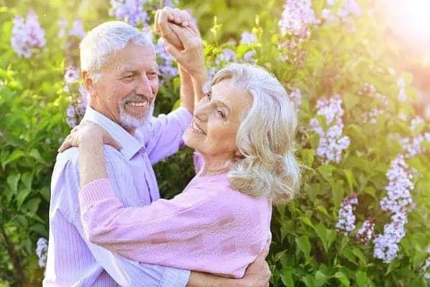 Old couple dancing in a park