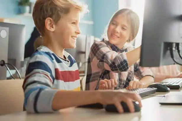 A young boy and girl sitting together in the class