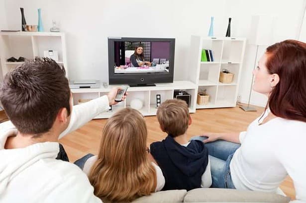 Children watching tv with parents
