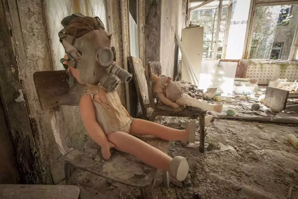 Top 10 Interesting Facts About Chernobyl: In 10 Minutes! 4 Old doll with a gas mask sitting on a chair in an abandoned kindergarten in Pripyat - Chernobyl nuclear power plant zone of alienation