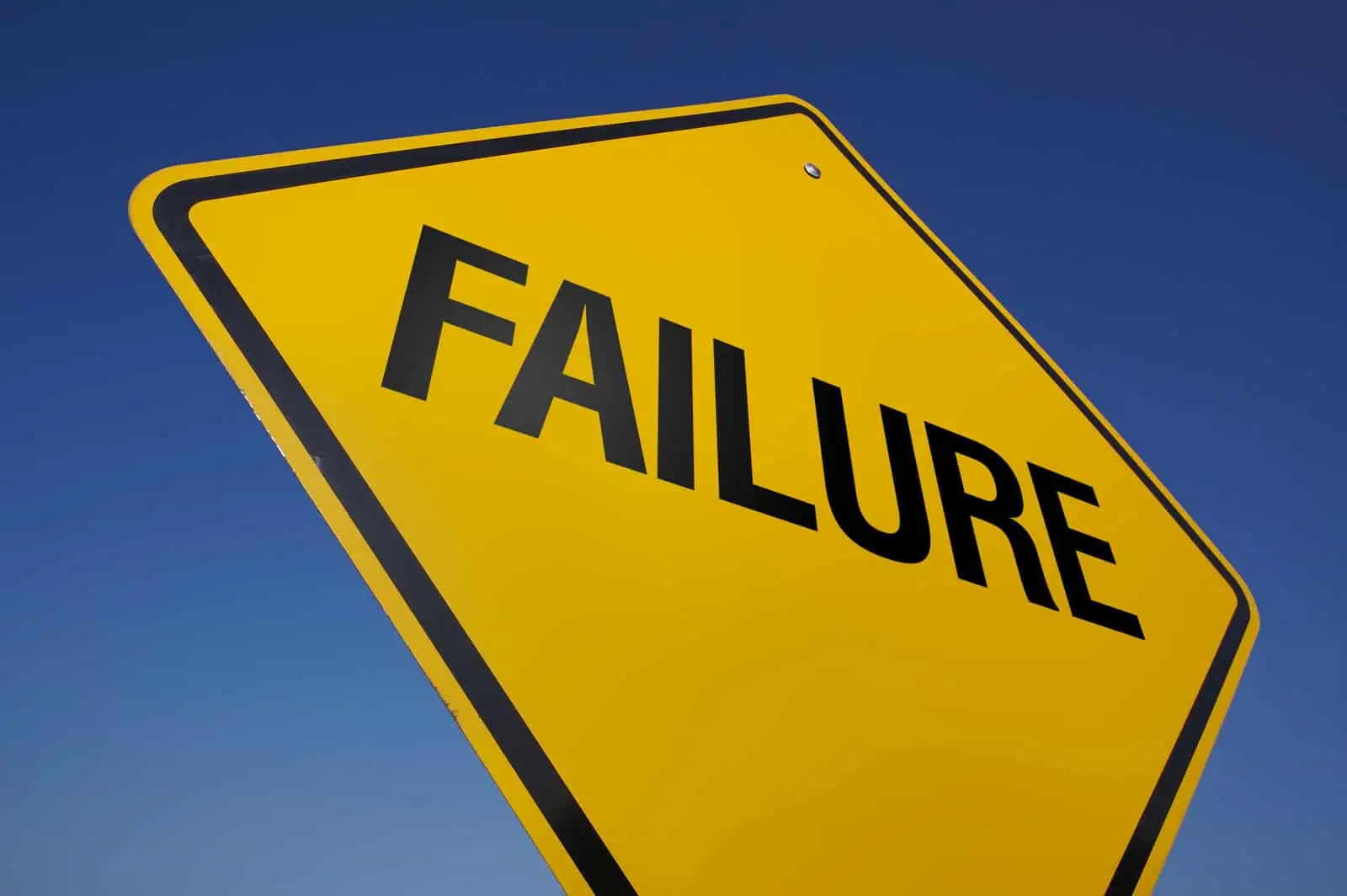 Yellow FAILURE road sign against a blue sky.