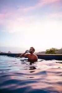 A guy enjoying drinks while a refreshing bath