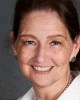 Healthy woman smiling with clear skin and brown hair.
