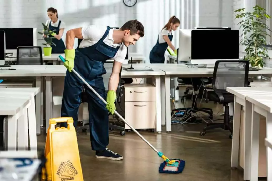 How to Do Wet Cleaning? The Top Tips 2 Young, smiling cleaner washing floor with mop