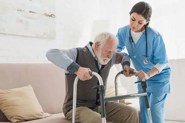 Doctor helping to retired man, to help him get up.
