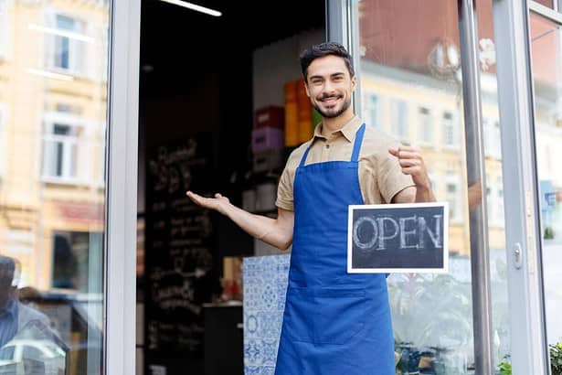 Small business owner with open sign.