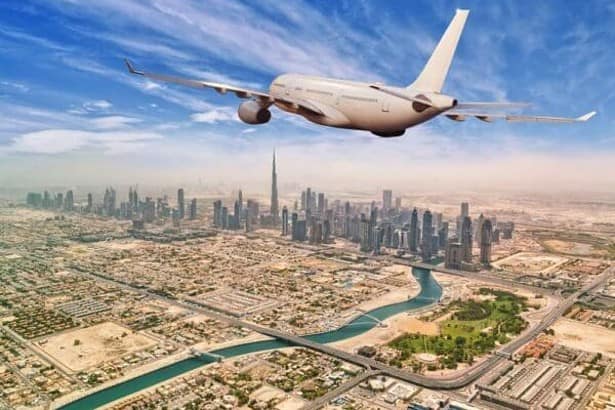 Commercial airplane flying above Dubai city. Aerial view of Dubai downtown.