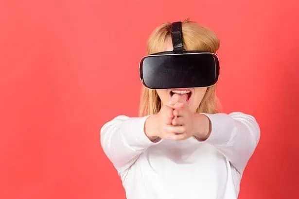 Excited smiling businesswoman wearing virtual reality glasses. Happy young woman wearing virtual reality goggles watching movies or playing video games. Funny young woman with VR