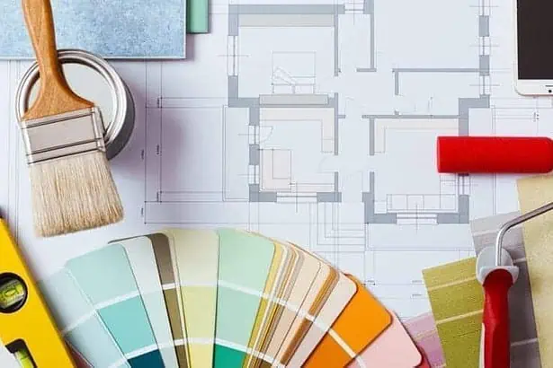 Painter and decorator work table with house project, color swatches, painting roller, brush and tools, top view.