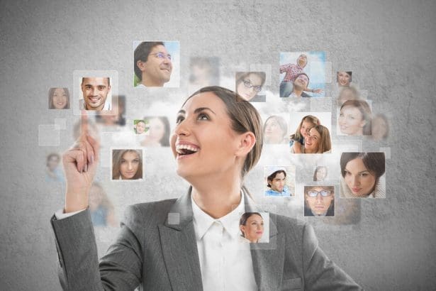 Young successful business woman looking at people portraits. International communication and recruitment concept.