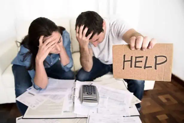 young couple worried need help in stress at home couch accounting debt bills bank papers expenses and payments feeling desperate in bad financial situation.