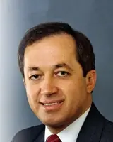 Smiling businessman in formal attire, professional headshot.