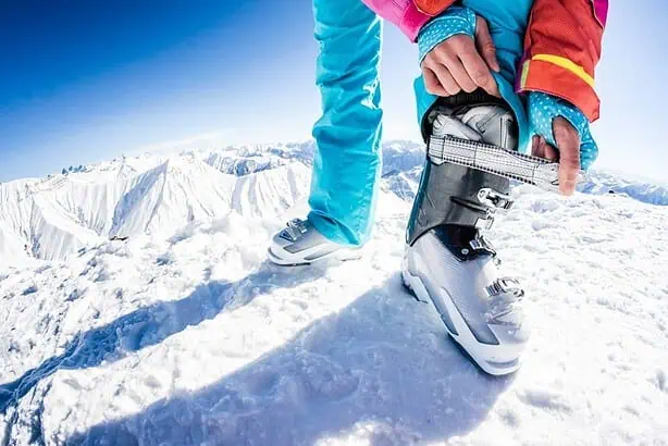 Female skier fastening her boots
