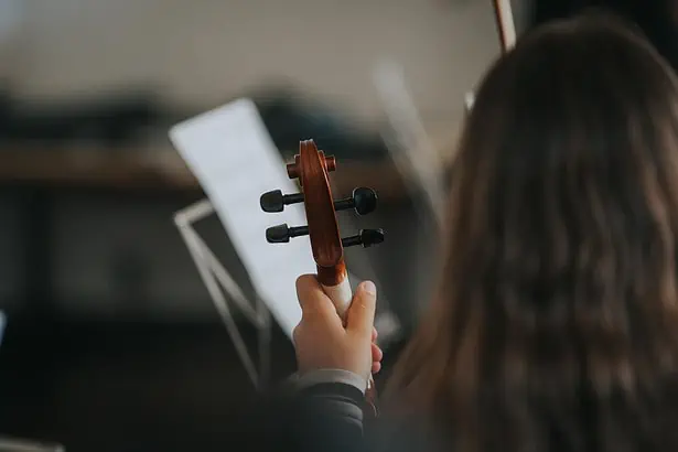 Violin player using tablet for music rehearsal.