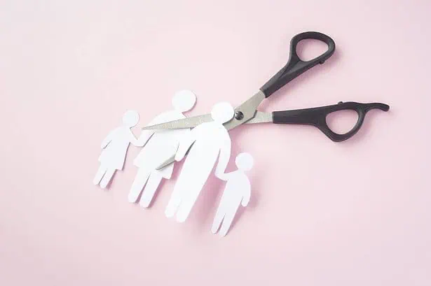 Scissor cutting out couple made of paper