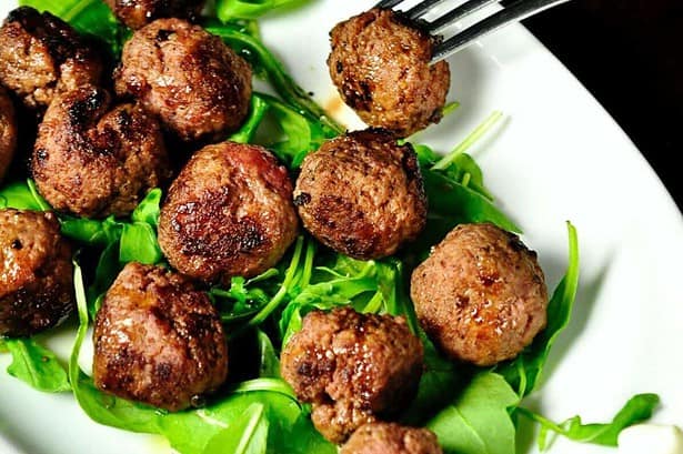 delicious meatballs with mint leaves kept on a plate