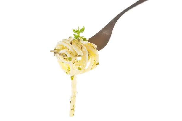 A person taking a bite of spaghetti with fork