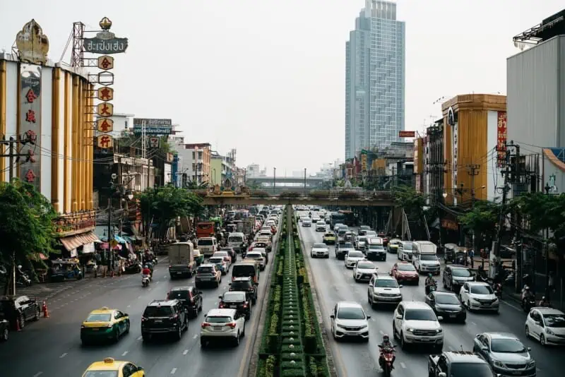 Busy Bangkok street with cars and skyscrapers in the background.