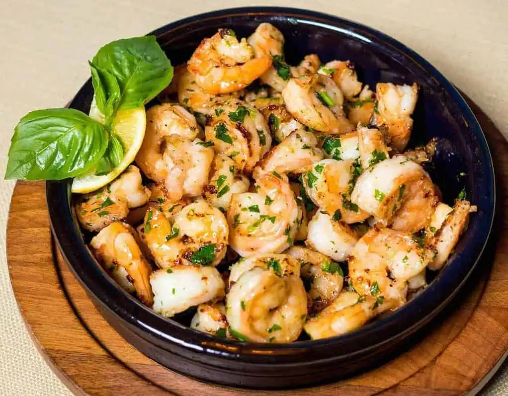 shrimp seasoned with lemons and mint leaves in a bowl