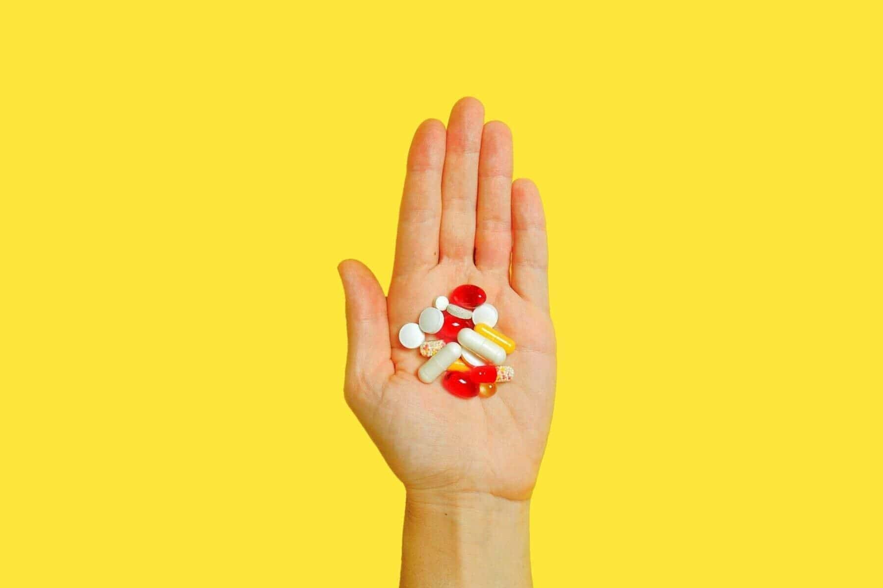 Person with bunch of pills on hand