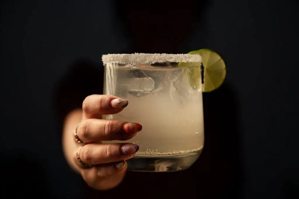A glass rimmed with salt and a lime wedge.