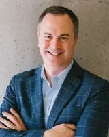 Confident businessman smiling in a blue suit, professional portrait.