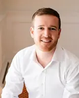 A smiling man in a white shirt, looking friendly and approachable, suitable for professional or pers.