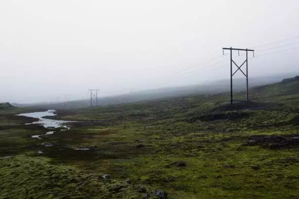 Misty landscape with power lines and electricity poles.