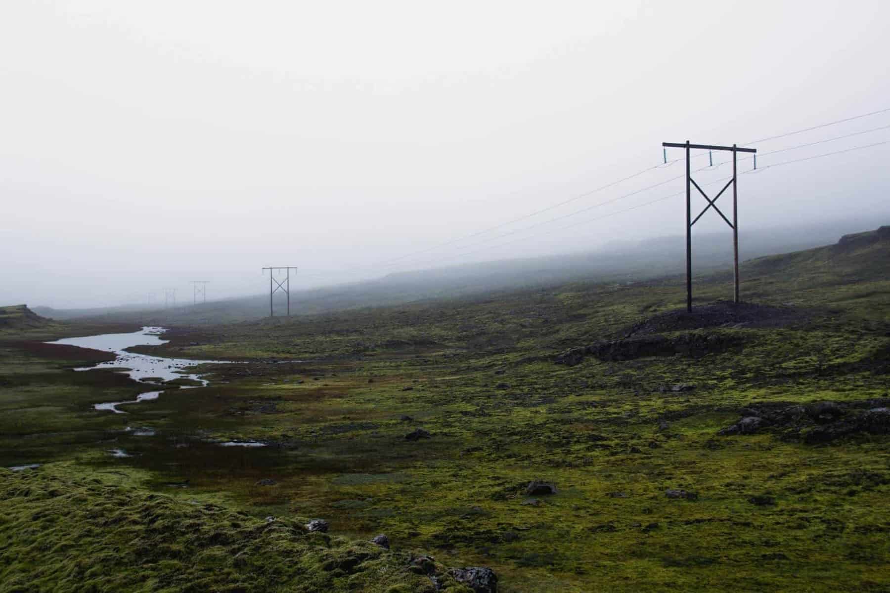 Misty landscape with power lines and electricity poles.