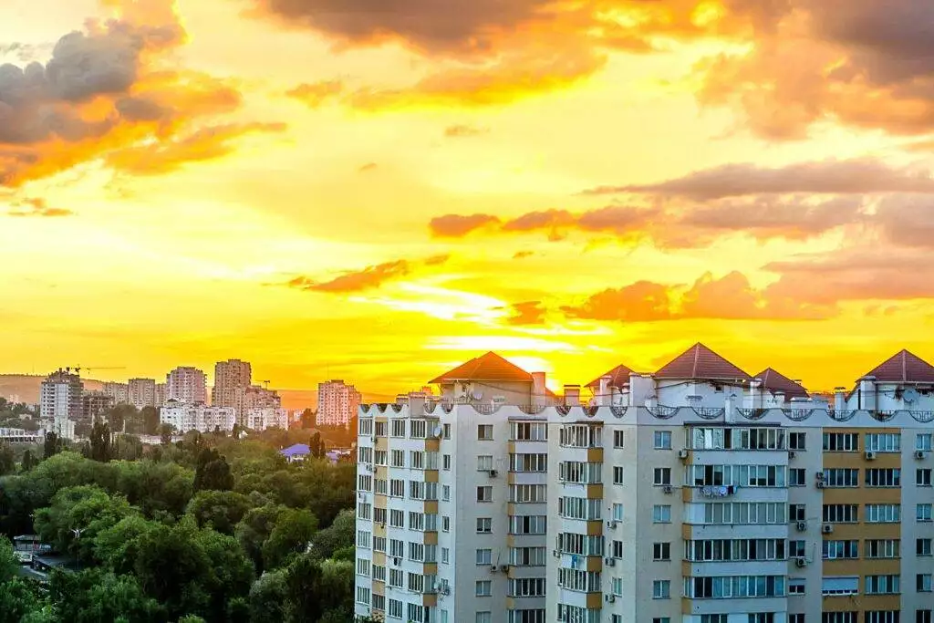 A series of apartment buildings with a sunny and cloudy sky.