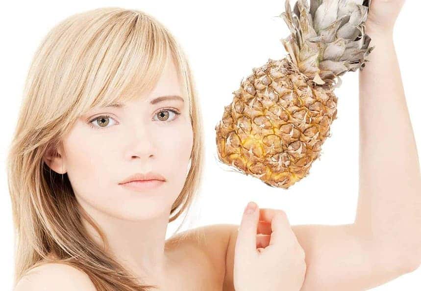A woman holding a pineapple.