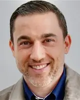 Confident businessman smiling in office setting, professional attire.