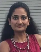 Woman dressed in vibrant traditional clothing with jewelry, celebrating cultural festival.