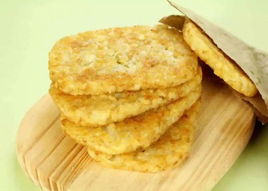 Stack of fried hash browns on a board ready to serve