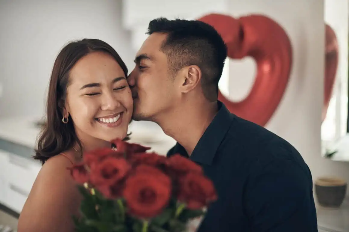  young man kissing his wife on the cheek