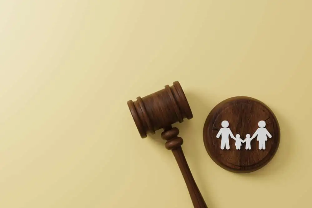 Wooden gavel and family justice symbol on a light background.