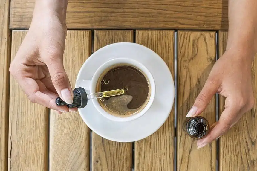 Adding CBD oil to coffee, wellness trend concept.