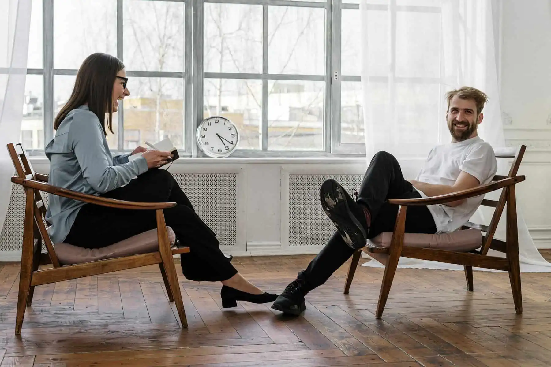 Two adults having a conversation indoors.